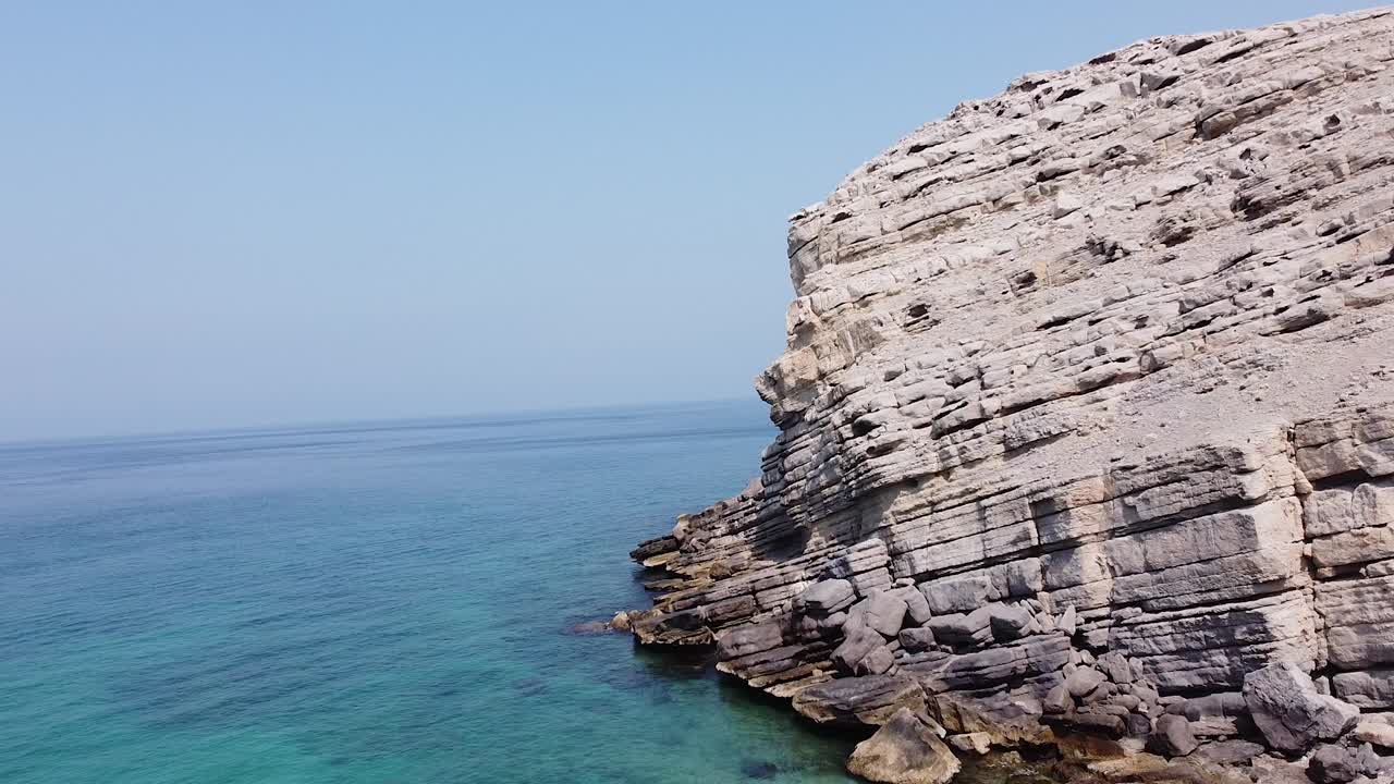 Drone shot of rocky mountain beach in Oman