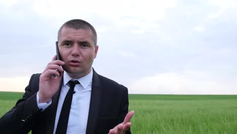 young businessman in business clothes speaks aggressively on a mobile phone young businessman in business clothes speaks aggressively on a mobile phone negative conversation evil leader