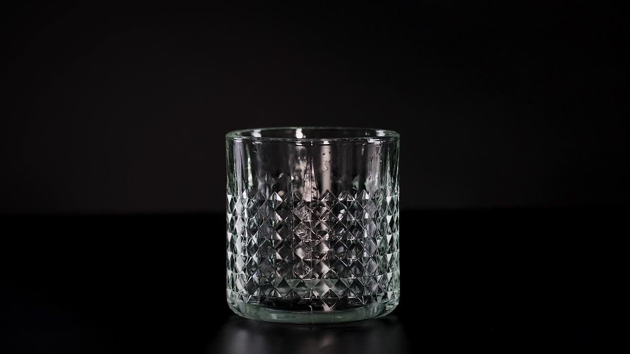 Isterning plasker ned i et tomt glas