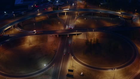 intersection circle transport junction at night city road with car traffic, aerial view from drone