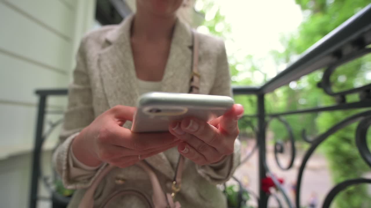 Close up of a woman scrolling on her phone at a terrace