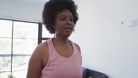 african american female plus size standing on exercise mat working out