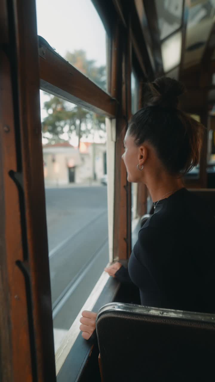 Donna su un tram che guarda fuori dal finestrino