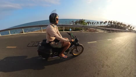 happy and relaxed traveler tourist smiling, cruising, and leisurely enjoying the coastal sunset in binh thuan, vietnam. travel and tourism in southeast asia.