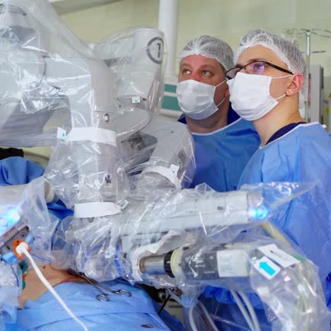 doctors in medical uniform near futuristic robot. surgery with modern robotic equipment. medical machine with robotic arms performing an operation. close-up