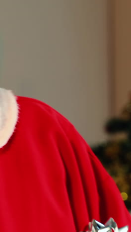 santa claus comprobando una caja de regalos y sonriendo