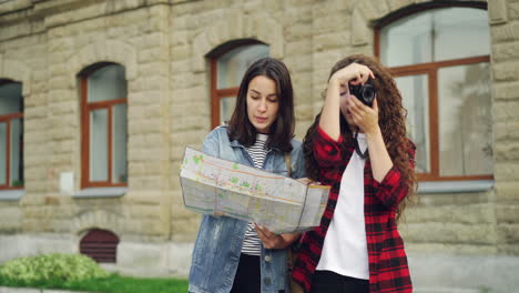 two women exploring a city with a map and camera