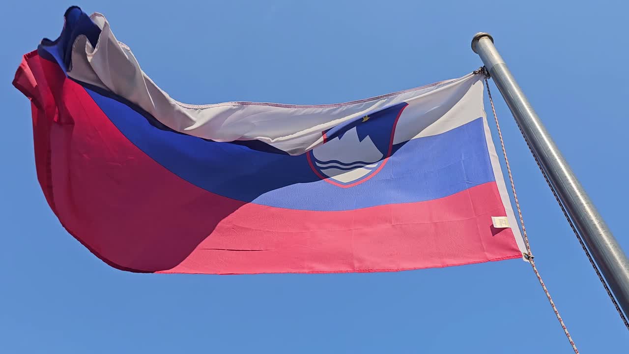 Nacionalistická slovenská vlajka se státním znakem silně vlající