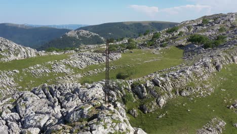 aerial drone view of a large iron cross on top of a mountain in the basque country