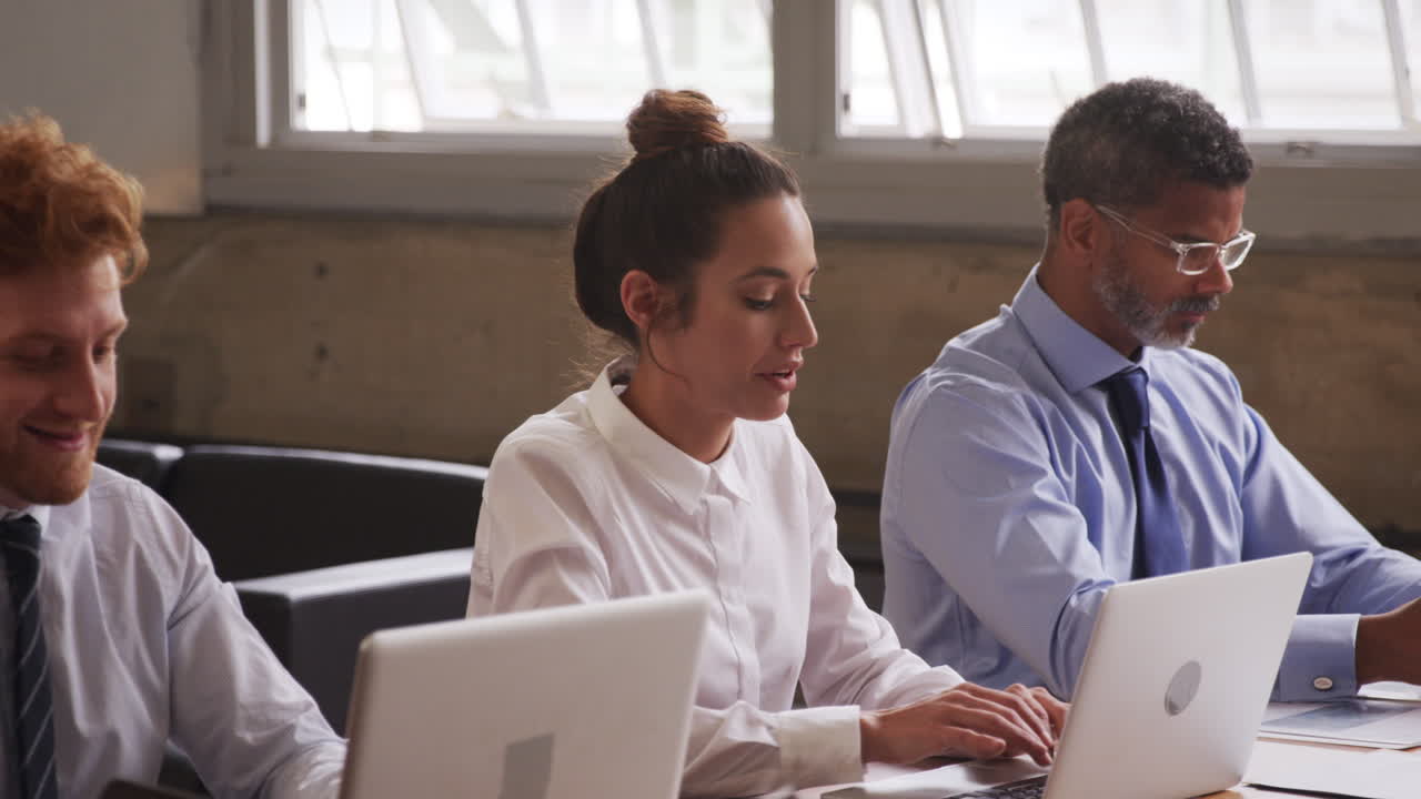 Colleghi di lavoro che prendono appunti e parlano durante una riunione.