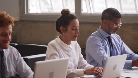 business colleagues taking notes and talking at a meeting