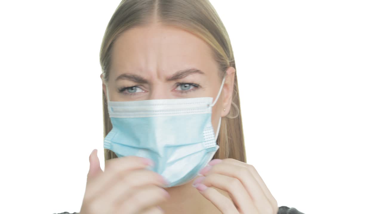 mujer frustrada se pone la máscara facial y luego la arranca con ira