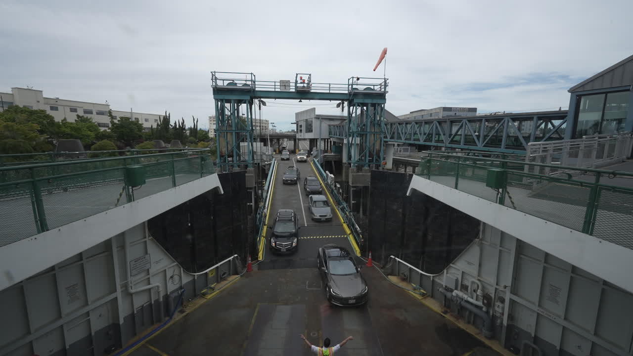 A timelapse video showing multiple vehicles driving swiftly onto a ferry, capturing the fast-paced boarding process at Bremerton Ferry Terminal .