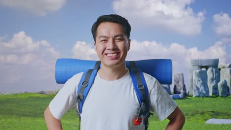 smiling tourist with backpack in front of stonehenge