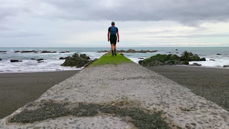 Un-Hombre-Saliendo-A-Una-Plataforma-Hacia-El-Océano