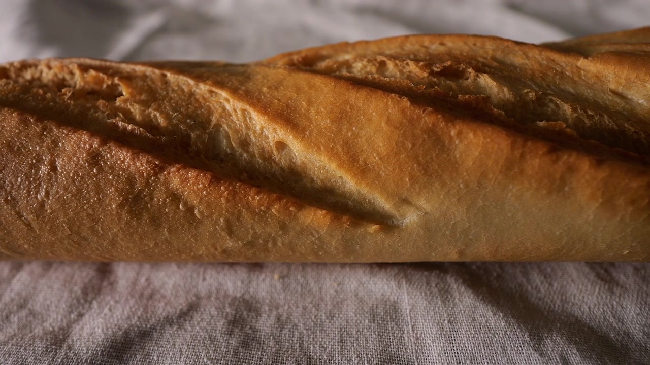 Ripresa dall'alto con slider a 50p che si muove sulla texture del pane rustico.