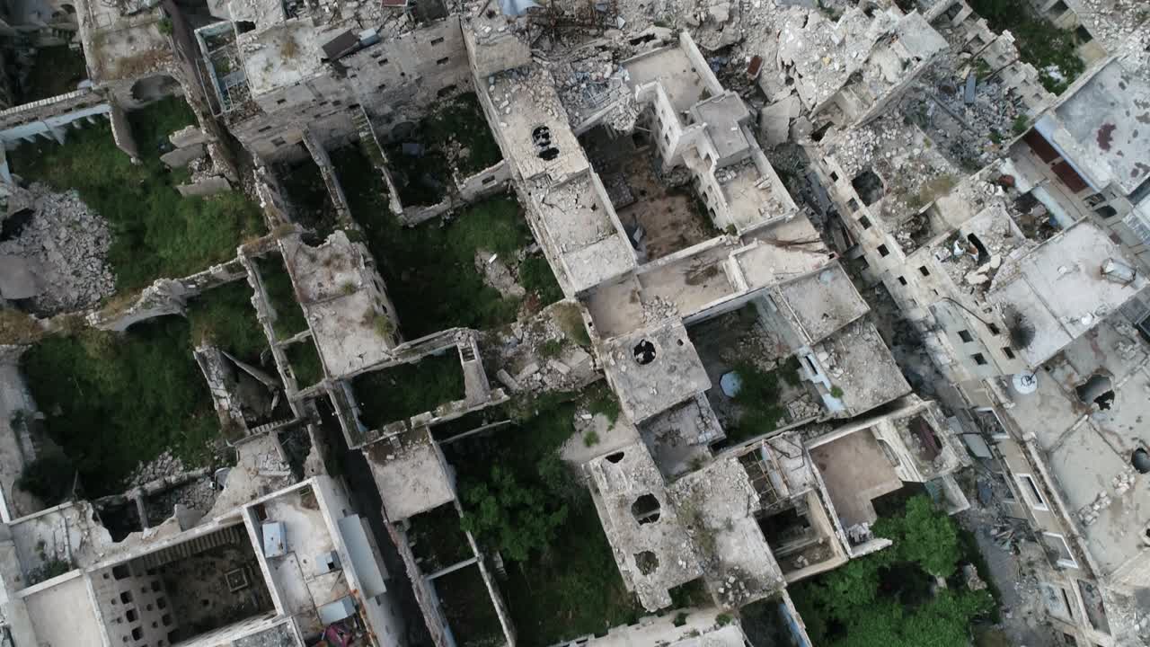vista aérea sobre los edificios de alepo en siria 10 años después de la guerra civil. podemos ver la hierba que cubre las ruinas del edificio, destruido después del bombardeo 4k