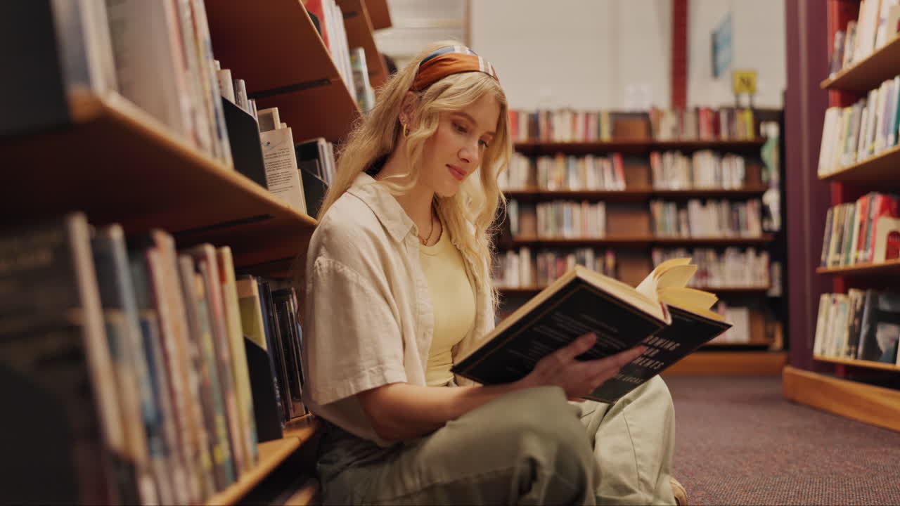 mujer leyendo un libro en una biblioteca