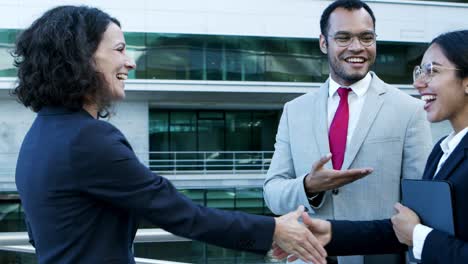 happy business colleagues shaking hands