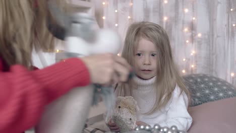 kid in sweater watches mom play with new year themed toys