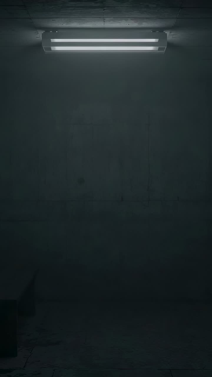 Vertical video: Flickering fluorescent light revealing concrete bench and stained floor in cellar