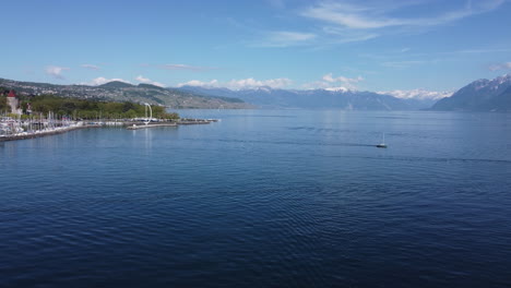 Aerial-shot-of-a-unique-structure-on-a-dock-area-along-the-Lake-Geneva-waterfront-in-Lausanne,-Switzerland-on-a-sunny-day