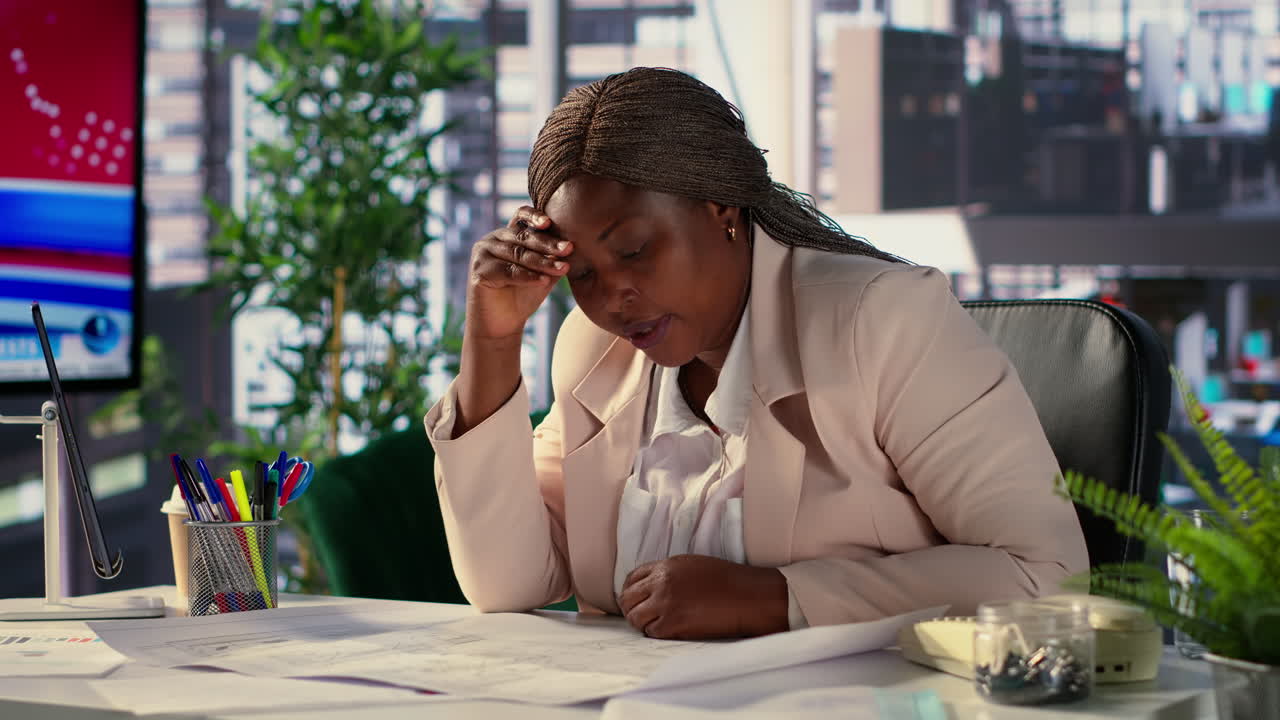 Focused businesswoman reviewing blueprints in an office setting