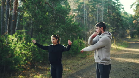 couple stretching outdoors in forest