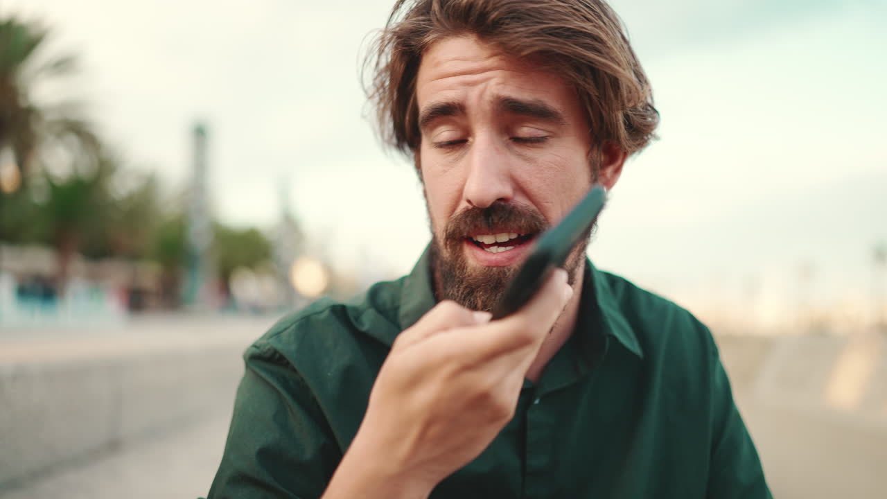 Man using voice assistant on phone outdoors