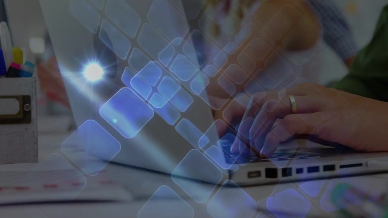 Team typing on laptop, blue diamond sweeping across desk, revealing hands for business task