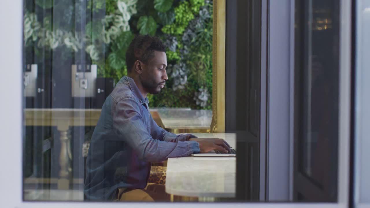 African american businessman using laptop in cafe