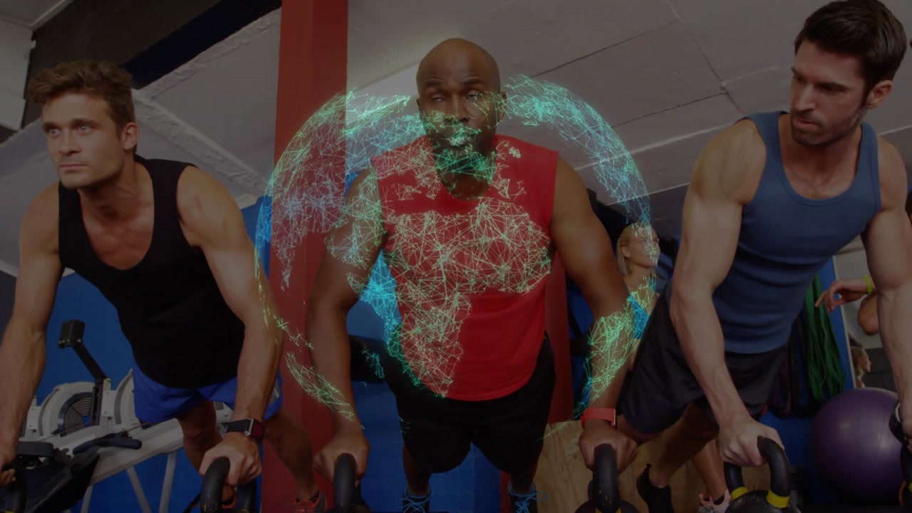Vertical video: Pressing on cue for fitness, center man in red top pushing kettlebell in gym, globe