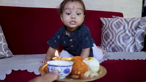 niño pequeño entusiasmado por comer dulces con motivo de raksha bandhan