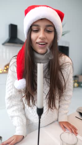 una joven soplando una vela de navidad