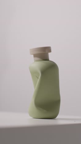 색 배경 에 찍힌 빈 압축 된 아름다움 제품 병 의 근접 사진