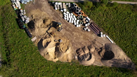 aerial top down - excavator operator operates the excavator on a construction site