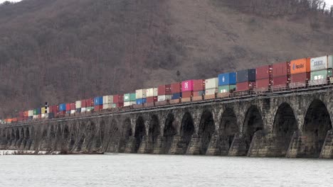 harrisburg, pennsylvania - january 7, 2021: train crossing a stone bridge over the susquehanna river near harrisburg, pennsylvania