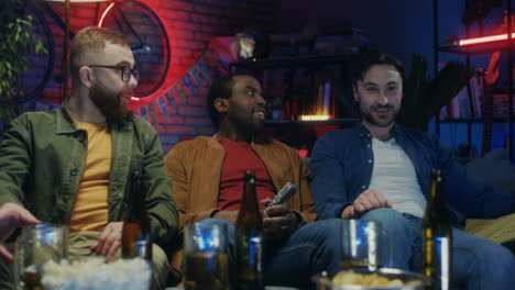 Razas-Mixtas-Apuestos-Hombres-Felices-Hablando-Con-Cerveza-Y-Bocadillos-Viendo-La-Televisión-Juntos-Por-La-Noche-En-Casa