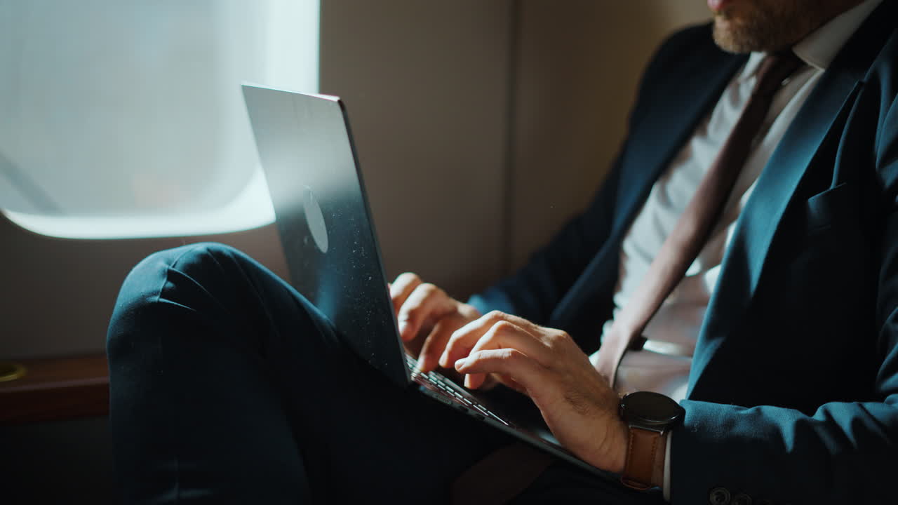 Businessman Working on Laptop During Airplane Flight