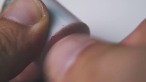 man turns pink pencil holding sharpener extreme close view