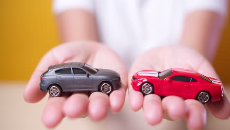 Spielzeugauto-In-Der-Hand-Der-Frau-Konzept-Für-Versicherung,-Kauf,-Miete,-Kraftstoff-Oder-Service--Und-Reparaturkosten