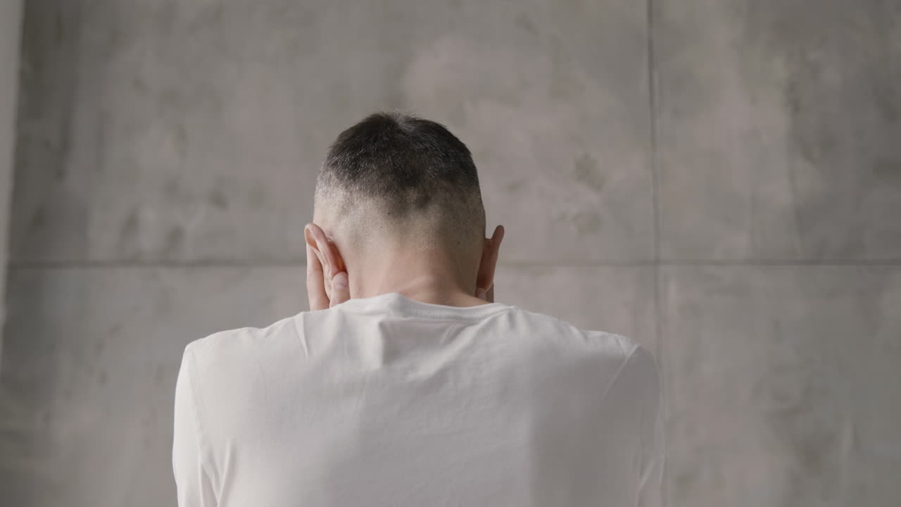 vista trasera de un hombre que sufre con dolor de cabeza en casa