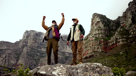 elderly hikers celebrate reaching mountain peak