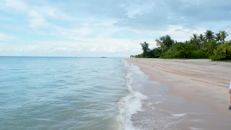 Girl-walks-on-tropical-beach-at-Langkawi-island-in-a-summer-day,-Malaysia