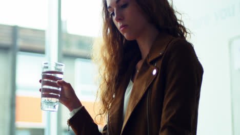 female executive drinking water at her desk