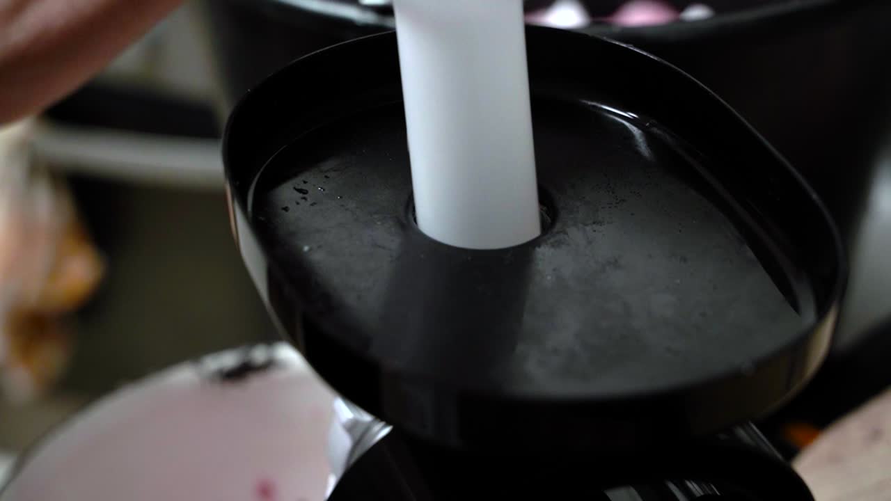 돼지 고기 연삭을 위해 현대 전기 고기 연삭기를 사용하는 여자