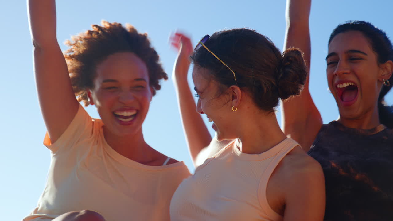 Close Up Portrait Of Laughing Female Friends Sitting Outdoors On Summer Day