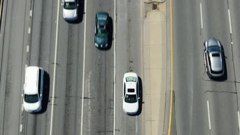 Perspectiva-Aérea-De-Arriba-Hacia-Abajo-Del-Tráfico-En-Una-Autopista-De-Varios-Carriles,-Calzada