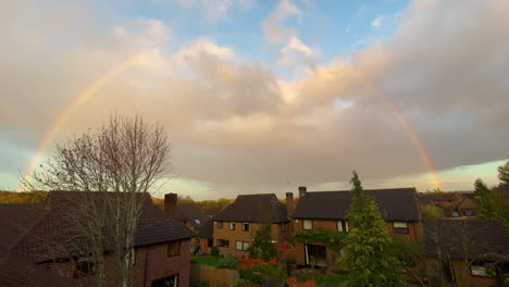 wide shot: rainbow over english suburban town houses