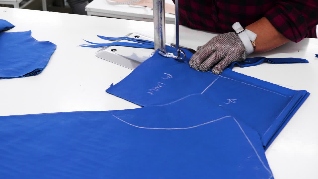 mujer que trabaja en una fábrica textil cortando telas